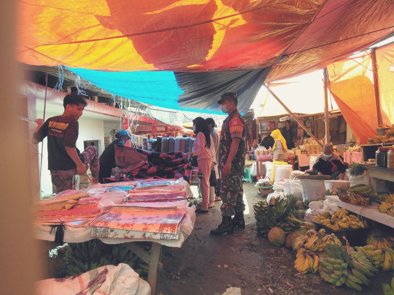 Sosialisasikan Kepatuhan Prokes dan 5M, Sertu Zulkifli Berbaur di Pasar Desa Pinasungkulan